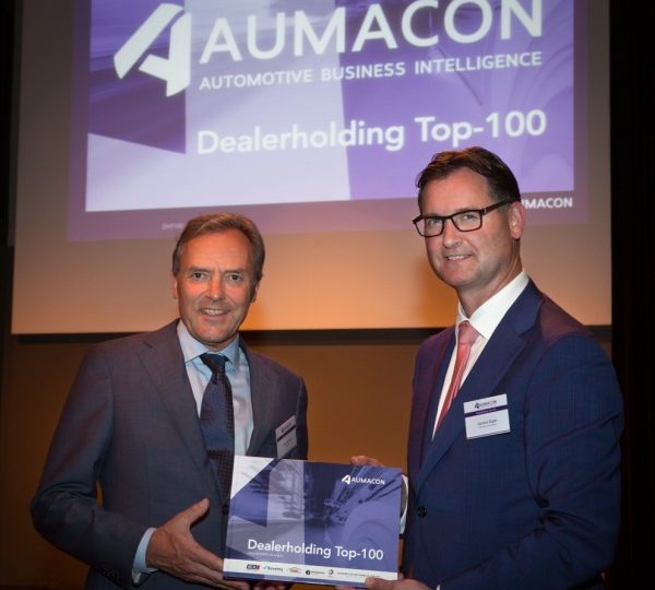 Overhandiging van het allereerste exemplaar van de Aumacon Dealerholding Top-100 editie 2015-2016 aan de heer Laurens Stigter (rechts), algemeen directie van Wensink Automotive, door Clem Dickmann, di
